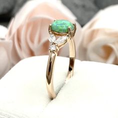 This beautiful ring is made from genuine 925 sterling silver with rose gold plating. Ring details- -The Main stone is an oval cut 7mm Lab Created Green Opal -Side stones are 4mm by 2mm clear Marquise and 1.3mm Round simulated diamonds -Ring is casted in solid 925 sterling silver with rose gold plating (yellow gold and rhodium plated also available, please check the drop down menu for more options) -The Total face height of the ring measures 7mms and the band width measures 1.4mms -Each ring is h Rose Gold Oval Ring For May Birthstone, Oval Emerald Ring In Rose Gold, Rose Gold Oval Emerald Ring, Diamond Leaf Ring, Ring Marquise, Simulated Diamond Rings, Fire Opal Ring, Ring Art Deco, Leaf Ring