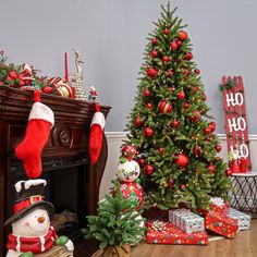 two christmas trees and presents in front of a fireplace