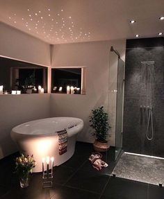 a white bath tub sitting inside of a bathroom next to a walk in shower stall