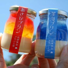 two people holding up jars with different colored liquid in them, one is blue and the other is orange