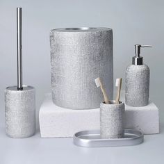 silver bathroom accessories on white surface with grey background