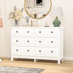 there is a white dresser with drawers and a mirror on the wall next to it