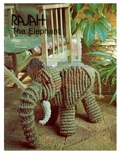 an elephant made out of yarn sitting on top of a wooden chair next to a plant