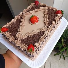 there is a cake with chocolate frosting and strawberries on the top, sitting on a plate