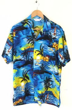 "-Description- >hand made colorful beach sunset print men's hawaiian shirt >button front >collared >open pocket on the front >small slits on the sides >size large >awesome print! >condition: excellent >color(s): multi >fabric(s): 100% polyester >brand: wuwatu >care: machine wash -Measurements- >size: large ✩ all measurements are taken with the item laying flat & some sizes are estimates so please check measurements ✩ chest: 48\" / 122cm length: 29.5\" / Blue Hawaiian Shirt With Tropical Print, Blue Hawaiian Shirt With Hibiscus Print For Beach, Blue Tropical Print Hawaiian Shirt With Camp Collar, Hawaiian Camp Shirt For Surfing, Blue Hawaiian Shirt For Beach Season Vacation, Blue Hawaiian Shirt For Vacation Beach Season, Summer Hawaiian Shirt For Surfing, Blue Hibiscus Print Camp Shirt For Vacation, Multicolor Hibiscus Print Camp Shirt With Short Sleeves