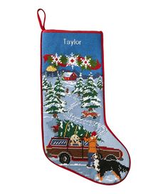 an embroidered christmas stocking with dogs and trees on it, featuring the name taylor