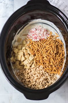 an overhead view of the ingredients in a crock pot for christmas crackers and pretzels