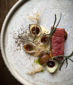 a white plate topped with food on top of a wooden table