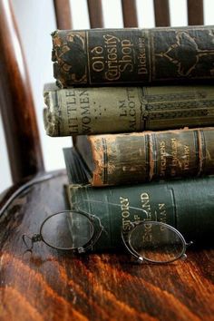 three books stacked on top of each other next to reading glasses and eyeglasses