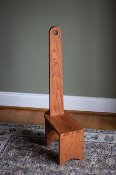 a wooden chair sitting on top of a rug