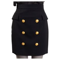 100% authentic Balmain high waisted mini skirt in black wool (100%). The design showcases large engraved decorative gold-tone buttons on the front, giving the piece that classic Balmain feel. Side flap pockets and a gold-tone metal zip fastening at the back. Lined in black viscose (52%) and cotton (48%). Has been worn and is in excellent condition. Measurements Tag Size 36 Size XS Waist From 66cm (25.7in) Hips From 88cm (34.3in) Length 47cm (18.3in) All our listings include only the listed item Chic Skirt With Gold Buttons For Work, Chic Fitted Skirt With Gold Buttons, Formal Mini Skirt With Button Closure, Formal Buttoned Mini Skirt, Classic Formal Skirt With Buttons, Formal Mini Skirt With Buttons, Elegant Formal Mini Skirt With Buttons, Luxury Fitted Gold Skirt, Elegant Black Pencil Skirt With Buttons