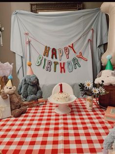 there is a birthday cake on the table with teddy bears around it and a banner that says happy birthday