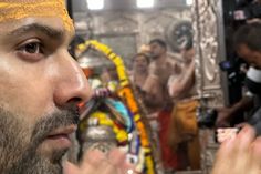 a man wearing a yellow turban is looking at his reflection in the mirror