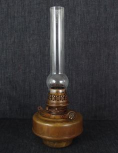 an old fashioned oil lamp sitting on top of a table