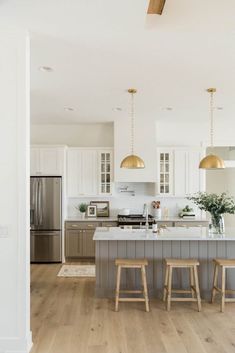 a kitchen with two stools next to an island