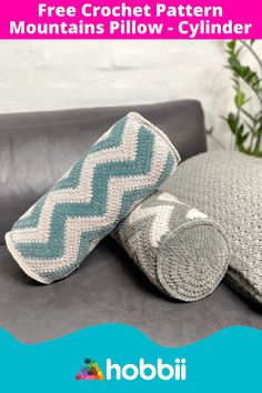 two crochet pillows sitting on top of a couch next to a pillow with the words free crochet pattern mountains pillow - cylinder