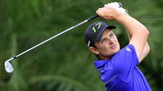 a man in blue shirt and black hat playing golf