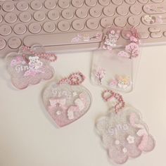 three pink heart shaped tags sitting on top of a keyboard