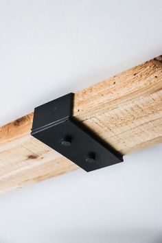 a close up of a wooden beam with black metal brackets on the top and bottom