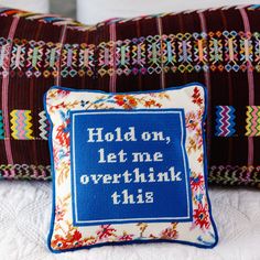 two decorative pillows with embroidered words on them