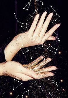 two hands with gold glitter on them reaching up into the air