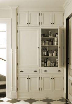 a kitchen with white cabinets and black and orange checkered flooring on the walls