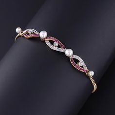 Antique Ruby, Diamond, and Pearl Bracelet: Transport yourself to the turn of the 20th century with this exquisite antique bracelet from 1900-1910, boasting a helix design accented with rose cut diamonds and natural channel set rubies, interspersed with four pearls. Set in platinum-topped 14k gold, this piece exudes timeless elegance and sophistication, perfect for adding a touch of vintage luxury to any ensemble. The bracelet measures 0.3 inches wide by 7 inches long and weighs 6.16 grams. It is Antique Bracelets, Ruby Diamond, Channel Set, Antique Shops, Rose Cut Diamond, Chain Link Bracelet, Pearl Bracelet, Rose Cut, Timeless Elegance