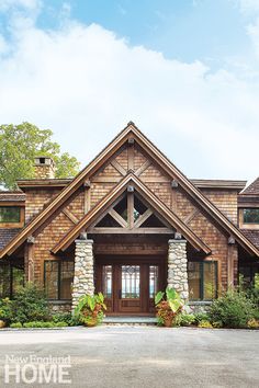 the front entrance to a large house with stone pillars and wood shingles on it