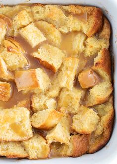 a casserole dish with bread and caramel sauce in the center, topped with croutons