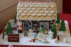 a decorated gingerbread house with snowmen and santa clause on the roof, surrounded by other decorations