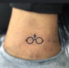 a small harry potter symbol tattoo on the back of a woman's ribcage