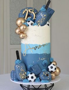 a blue and white cake with gold decorations on it's side, sitting on a table