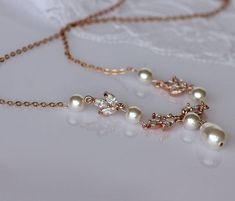 "Rose gold necklace in a leafy design combines with Swarovski pearls to create an understated bridal necklace. It can be paired with earrings and bracelets from our range also. 💜 Available in rose gold, silver (rhodium) and gold Please leave your required pearl color at checkout (ivory white, cream, cream blush) Matching earrings - available in Rose Gold, Gold and Silver www.etsy.com/listing/653979509 Measurements: Necklace length: Varying lengths adjustable with an extender (optional) Pendant Rose Gold Pearl Drop Necklace For Wedding, Rose Gold Pearl Chain Necklace For Wedding, Delicate Rose Gold Pearl Necklace For Wedding, Bridal Necklace Gold, Pearl Necklace Rose, Rose Gold Chandelier Earrings, Gold Crystal Necklace, Gold Bridal Necklace, Backdrops Necklace