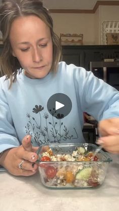 a woman sitting at a table with a bowl of food