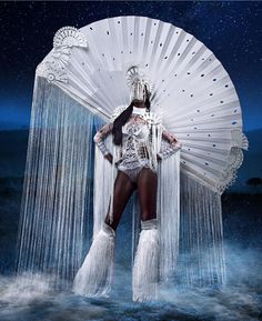 a woman dressed in white holding an umbrella