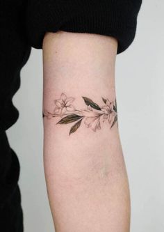 a woman's arm with a flower tattoo on the left side of her arm