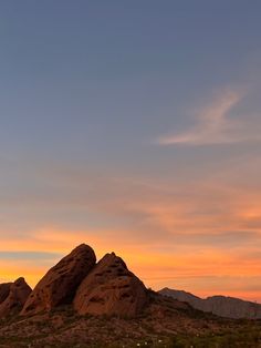 the sun is setting over some rocks in the desert