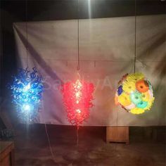 three different colored lights hanging from strings