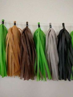 several different colors of tassels hanging on a line with black, brown, and green