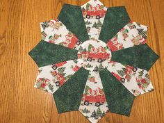 a green and white christmas tree skirt with santa clause on the front, red truck in the back