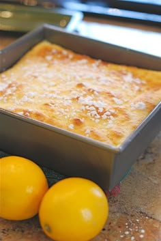 two lemons sit next to a pan of food