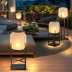 a living room filled with lots of furniture and lamps on top of wooden flooring