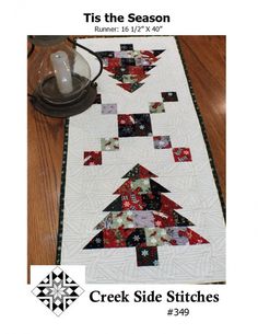 a quilted table runner with a christmas tree design on the front and back side