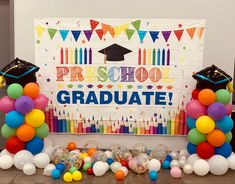 balloons and streamers surround the backdrop for a graduation celebration