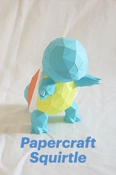 the papercraft squirtle is sitting on a white sheet