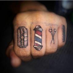 a person with tattoos on their fingers holding a comb and scissors in one hand while the other is wearing a barber's hat