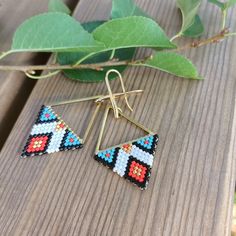 a pair of earrings sitting on top of a wooden table