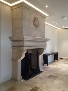 a large fireplace in the middle of a room with white walls and beige flooring