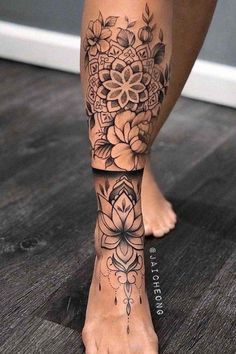 a woman's foot with flowers on it and an intricate tattoo design in the middle