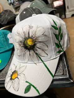 a white hat with flowers painted on it